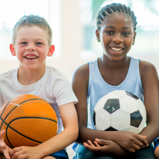 Two little boys playing ball smiling 